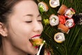 Smiling young Korean girl eating sushi rolls Royalty Free Stock Photo