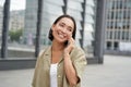Smiling young korean girl talking on mobile phone and walking in city. Happy woman posing on street with smartphone Royalty Free Stock Photo