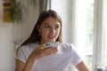 Smiling young lady holding modern mobile phone recording audio message Royalty Free Stock Photo