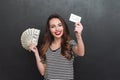 Smiling young lady holding money and debit card in hands Royalty Free Stock Photo