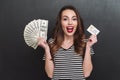 Smiling young lady holding money and debit card in hands Royalty Free Stock Photo