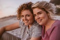 Smiling young lesbian couple enjoying a romantic beach sunset together Royalty Free Stock Photo