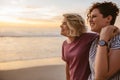 Smiling lesbian couple watching the sunset together at a beach Royalty Free Stock Photo