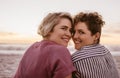 Smiling young lesbian couple watching a romantic beach sunset Royalty Free Stock Photo