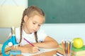 Smiling young little child girl writing in school. Education and school concept Royalty Free Stock Photo