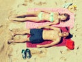 Smiling young lovers sunbathing at sandy beach Royalty Free Stock Photo