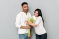 Smiling young loving couple standing over grey wall Royalty Free Stock Photo