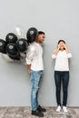Smiling young loving couple standing over grey wall Royalty Free Stock Photo
