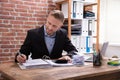 Male Accountant Calculating Invoice With Calculator In Office Royalty Free Stock Photo