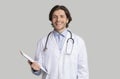 Smiling young male doctor in white coat with stethoscope and clipboard Royalty Free Stock Photo