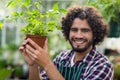 Smiling young male gardener holding potted plant Royalty Free Stock Photo