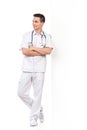 Smiling young male nurse lean on the wall Royalty Free Stock Photo