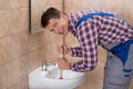 Male Plumber Using Plunger In Sink