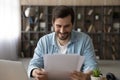 Smiling young male remote employee receive paper letter of accreditation Royalty Free Stock Photo