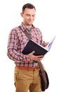Smiling young male student looking at an open book Royalty Free Stock Photo