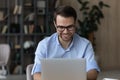 Smiling young male worker use computer type document at desk