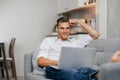 smiling young man browsing Internet while lying on the couch. Royalty Free Stock Photo