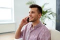 Smiling young man calling on smartphone at office Royalty Free Stock Photo
