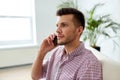 Smiling young man calling on smartphone at office Royalty Free Stock Photo