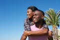 Smiling young man carrying girlfriend on back