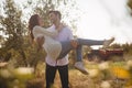 Smiling young man carrying girlfriend at olive farm