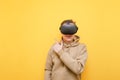 Smiling young man in casual clothes wears VR glasses, stands on a yellow background and points his finger at Copy space. Happy guy Royalty Free Stock Photo
