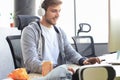 Smiling young man in casual clothing using computer, streaming playthrough or walkthrough video Royalty Free Stock Photo