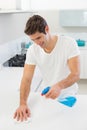Smiling young man cleaning kitchen counter Royalty Free Stock Photo