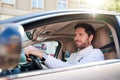 Smiling young man driving his car during his morning commute Royalty Free Stock Photo