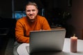 Smiling young man enjoying distant dating using laptop computer, holding glass with wine , talking celebration toasting Royalty Free Stock Photo