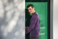 Smiling young man entering a door