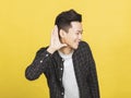 smiling young man hand over ear listening an hearing to rumor or gossip Royalty Free Stock Photo