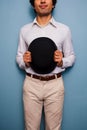 Smiling young man holding a bowler hat Royalty Free Stock Photo