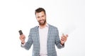 Smiling young man holding gazette and mobile phone.