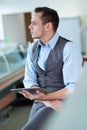 Smiling young man holding tablet computer