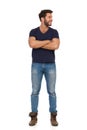 Smiling Young Man In Jeans And Blue T-shirt Is Standing With Arms Crossed And Looking Away Royalty Free Stock Photo