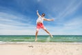 Smiling young man jumping on summer beach Royalty Free Stock Photo