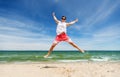 Smiling young man jumping on summer beach Royalty Free Stock Photo