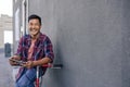 Smiling young man leaning on his bicycle using a tablet Royalty Free Stock Photo