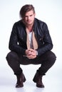 Smiling young man in leather jacket standing crouched Royalty Free Stock Photo