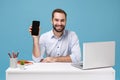 Smiling young man in light shirt sit work at desk with pc laptop isolated on pastel blue background. Achievement Royalty Free Stock Photo