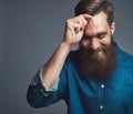 Smiling young man with a beard styling his hair Royalty Free Stock Photo