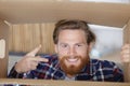smiling young man looking into cardboard box Royalty Free Stock Photo