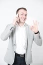 Smiling young man looking at his smart phone while text messaging on white Royalty Free Stock Photo