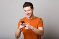 Smiling young man looking at text message on mobile phone Royalty Free Stock Photo