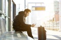 Smiling young man with mobile phone and bag Royalty Free Stock Photo