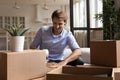 Smiling young man packing belongings in carton boxes. Royalty Free Stock Photo