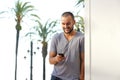 Smiling young man reading text message on mobile phone Royalty Free Stock Photo