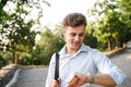 Smiling young man in shirt walking at the city park Royalty Free Stock Photo