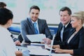 Smiling young man sitting at a business meeting with colleagues. Royalty Free Stock Photo